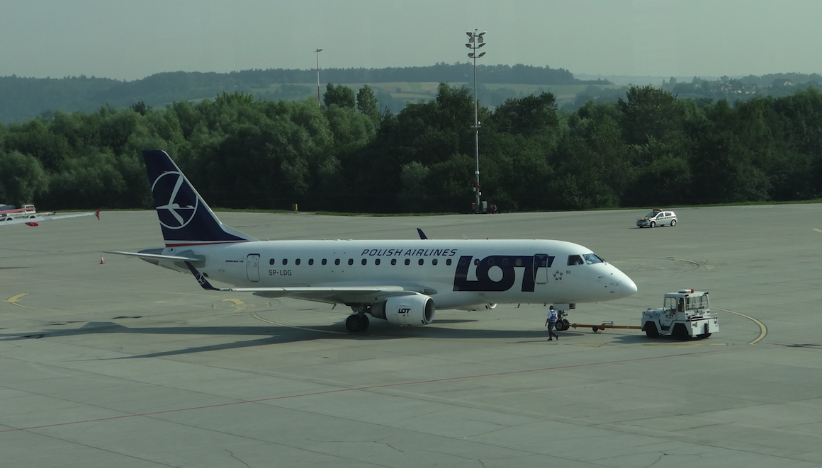 TUG airport tractor pushes PLL LOT Embraer 170STD aircraft, registration SP-LDG. 2012 year. Photo by Karol Placha Hetman