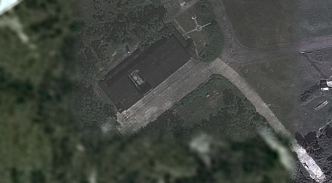 Lotnisko Wicko Morskie, budynek wielofunkcyjny – hangar, z zawalonym fragmentem dachu. 2013 rok. Zdjęcie Google mapy