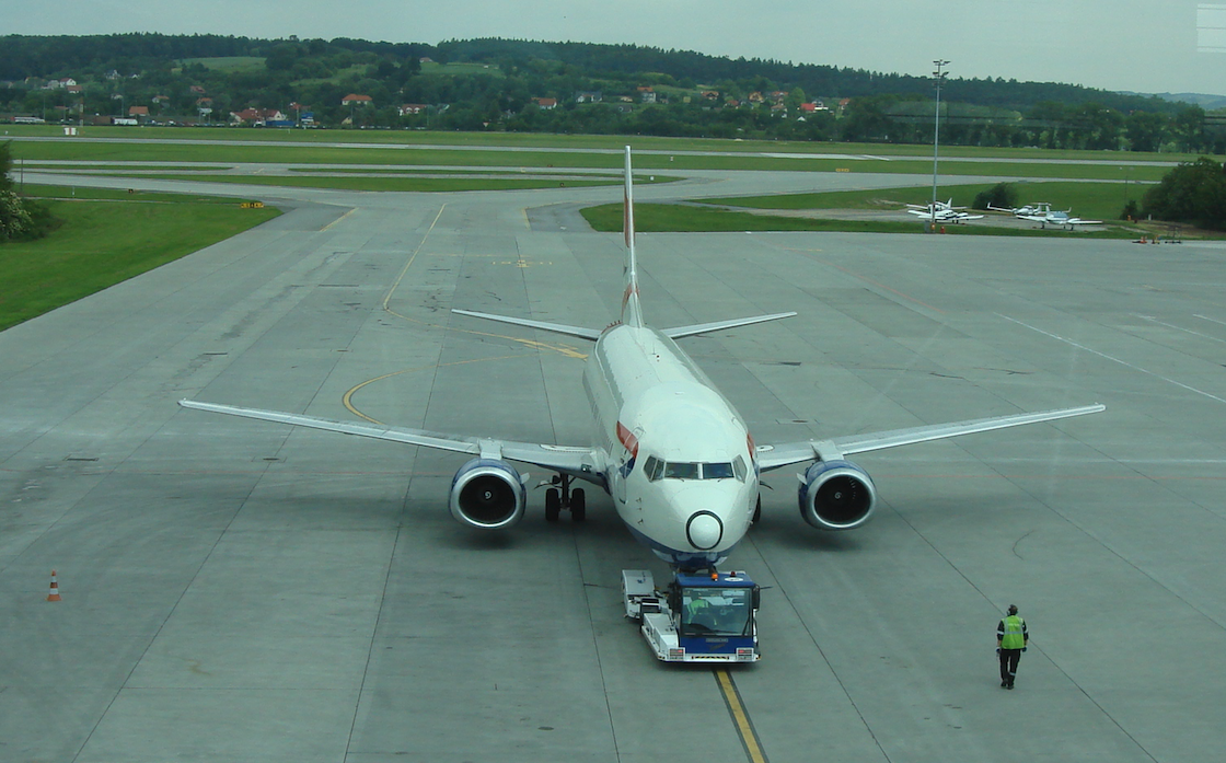 DOUGLAS airport tractor pushes Boeing B.737-400 aircraft. 2009 year. Photo by Karol Placha Hetman